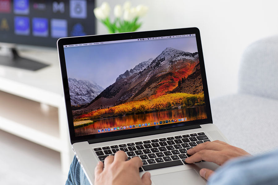 Customer examining MacBook Pro features before purchase at PayMore Santa Clarita